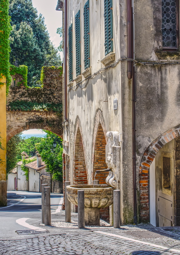 Stone fountain beneath an archway in Asolo